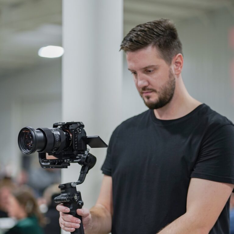 Oleg Kovalov holding a camera on a gimbal outdoors.